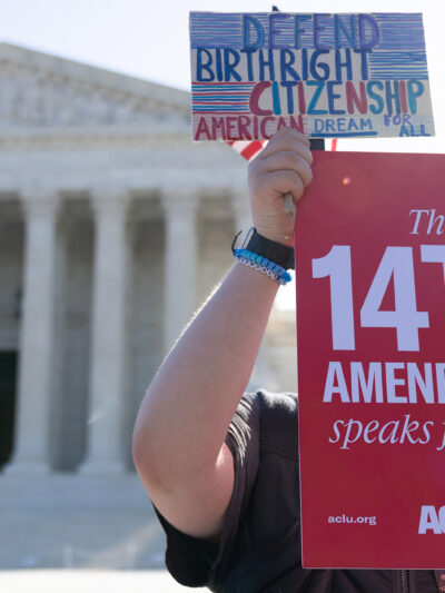 A demonstrator holding signs advocating for the 14th Amendment at the U.S. Supreme Court in Washington, D.C. for the birthright citizenship case Trump v. Barbara