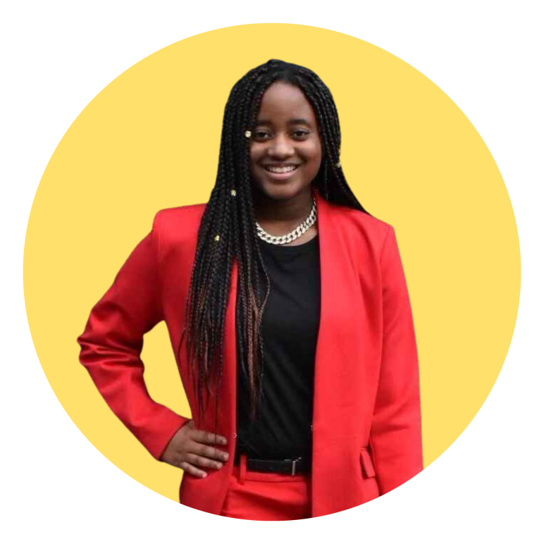 Allie Ball smiling in a red suit in front of a yellow semi circle