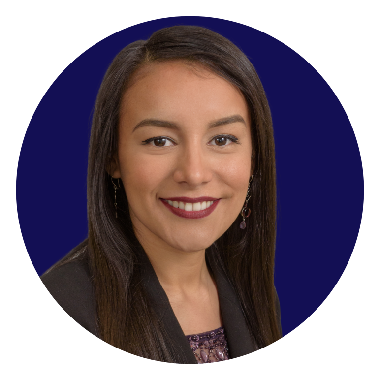 Andrea smiling in front of a navy blue background