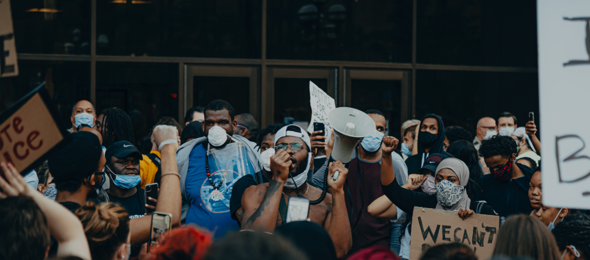 groups of protesters in front of glass doors. 