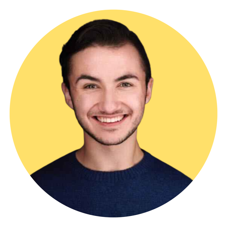 Jude smiling in a navy sweater in front of a yellow circle background
