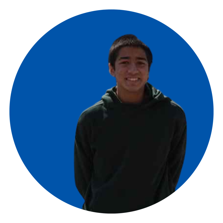 Yusuf Arifin wearing sweater smiling in front blue background