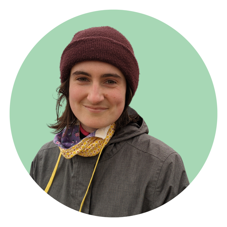 Savannah wearing a hat and smiling in front of a light green background