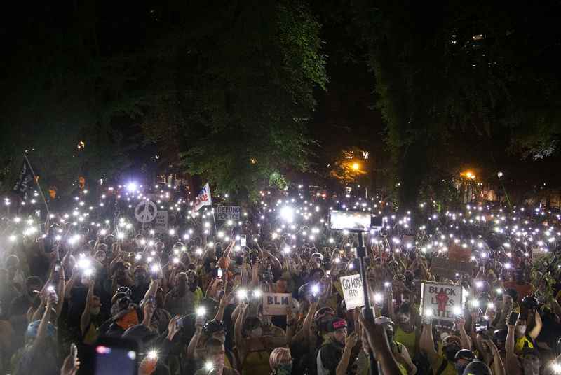 Thousands of protesters gather in downtown Portland in mid-July 2020. The authors write that People for Portland's call for additional police officers ignores the voices of thousands who marched for an end to systemic racism and police brutality.