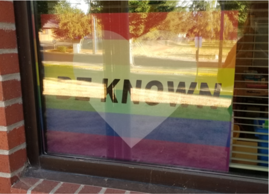 Rainbow sign with a heart and the words “Be Known” in Chelsea Shott's classroom window