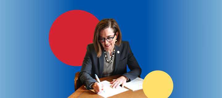Photo of Governor Kate Brown signing a page