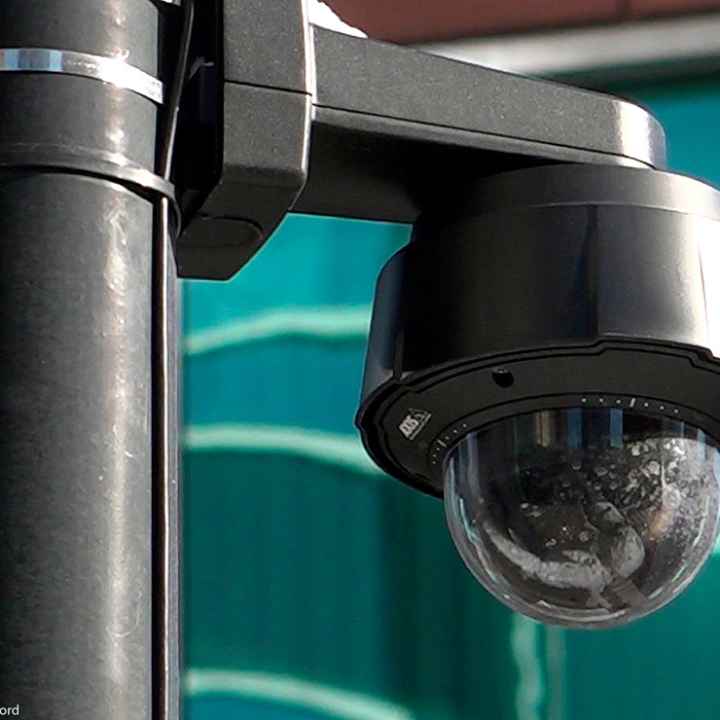 A close-up of a black surveillance camera on a black pole in Chicago.