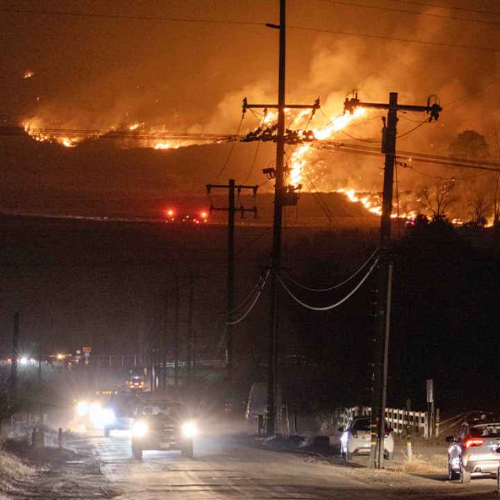 Hughes fire, in Castaic, burns on a hill threatening the freeway below while cars attempt to escape.