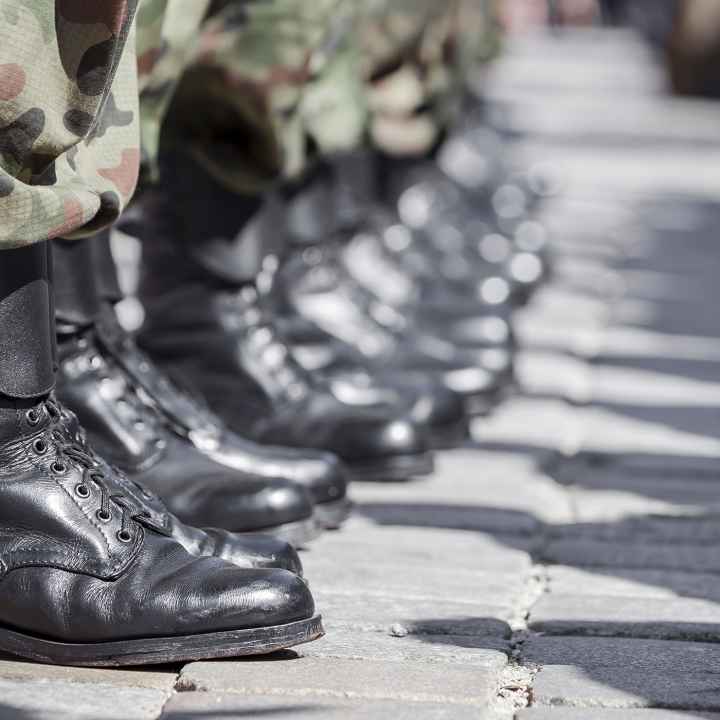 A row of boots belonging to military soldiers.