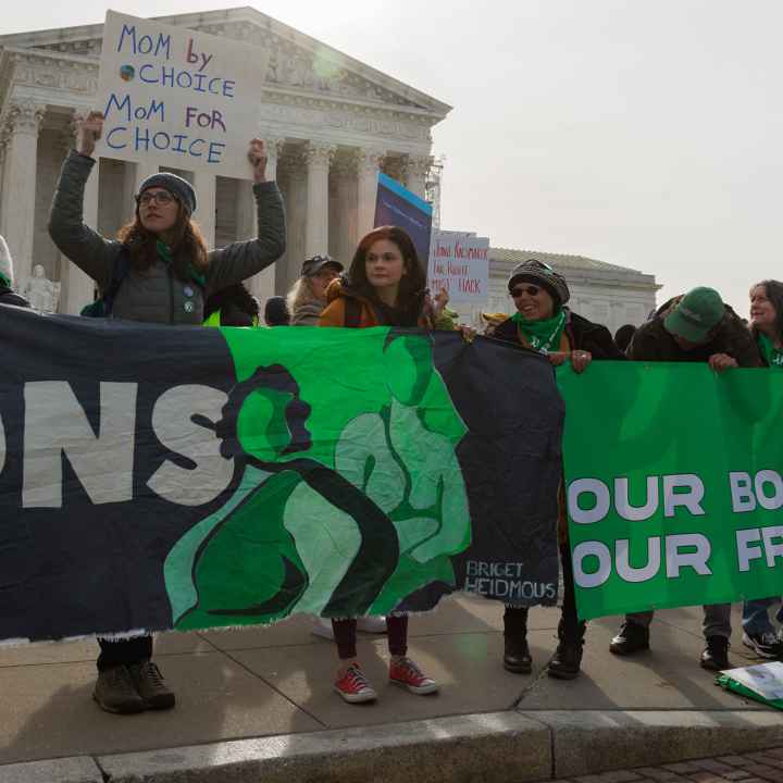 A group of demonstrators holding a banner saying "Our Bodies, Our Freedom."