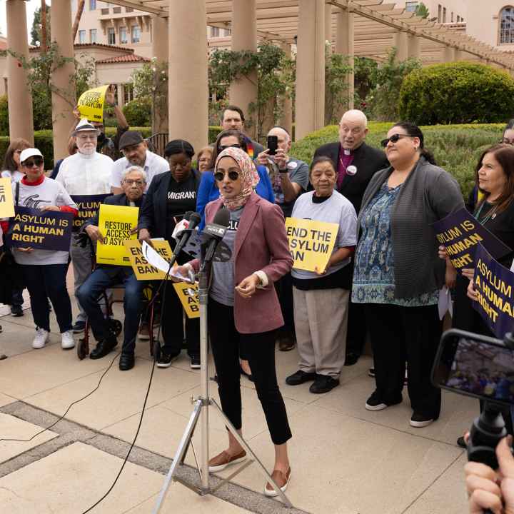 A woman speaking at a rally for asylum.