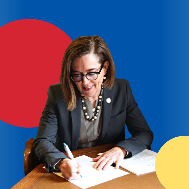 Photo of Governor Kate Brown signing a page