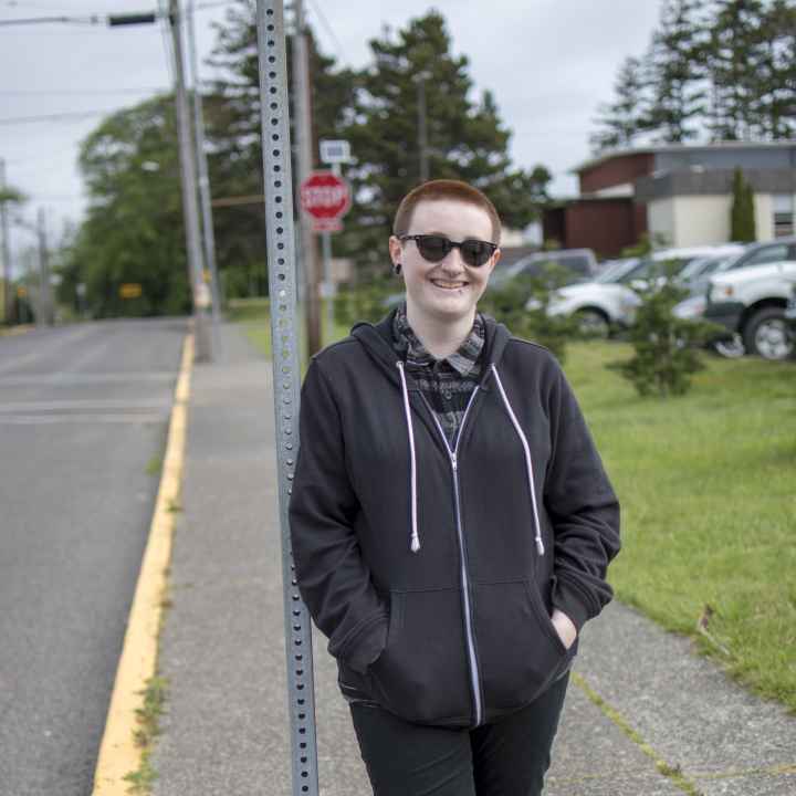 Hailey leans against a street sign