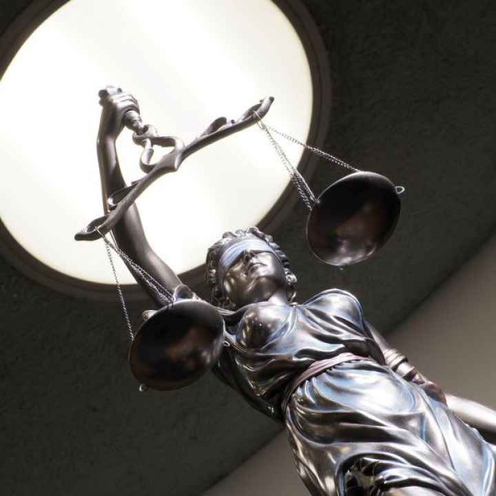 Image of brass statue holding scales in courtroom