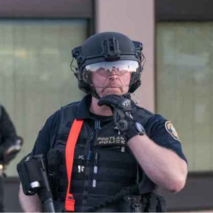 Photo of Portland police officer livestreaming protest Photo of Portland police officer livestreaming protest