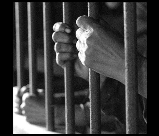 Hands behind bars.