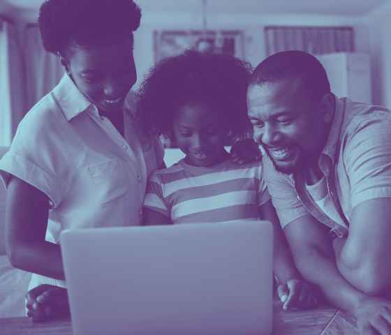 image of family grouped around a laptop