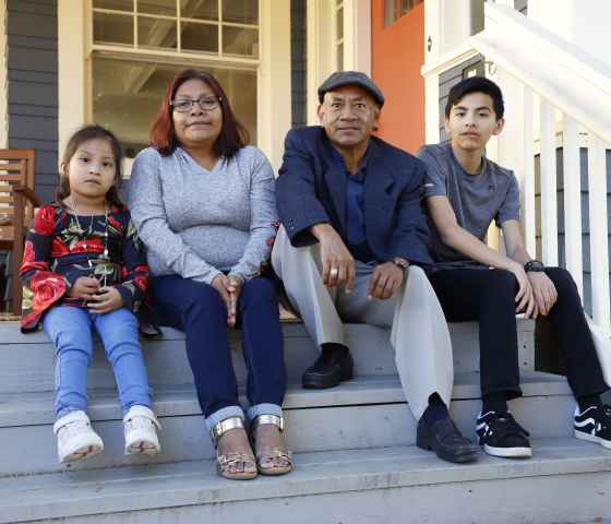 family on front steps of home