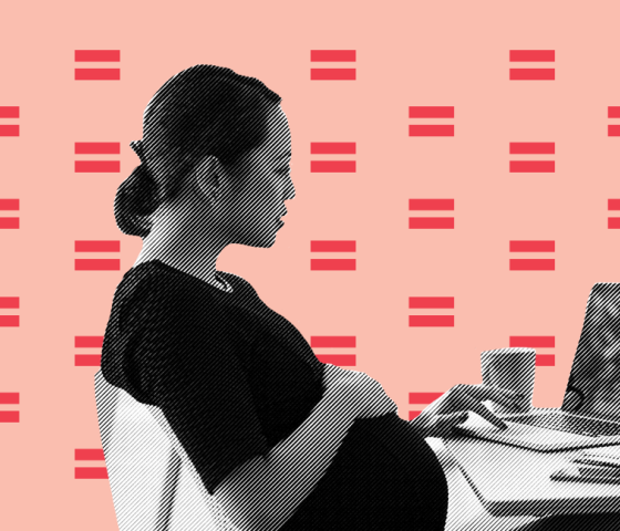 pregnant worker sits at desk with laptop